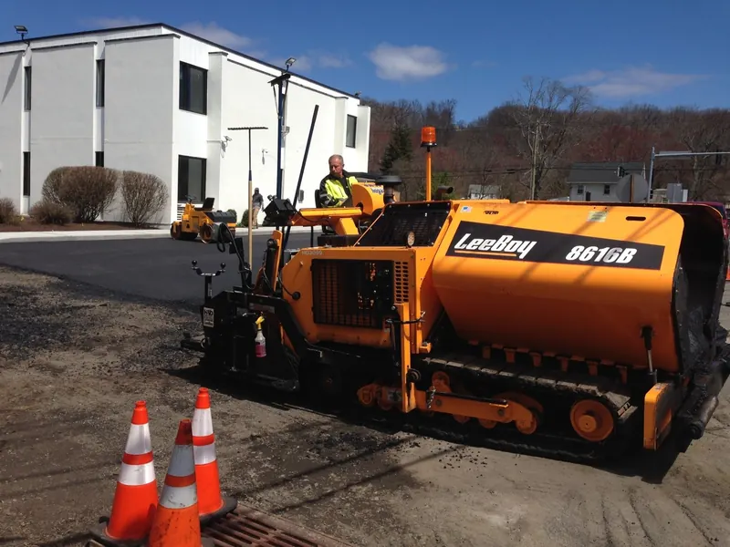 Our paver laying fresh asphalt on a commercial lot